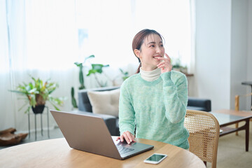 パソコンでの作業中に談笑する20代女性