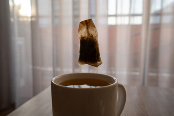 A mug of tea on a wooden table, sun, warm, cold. High quality photo