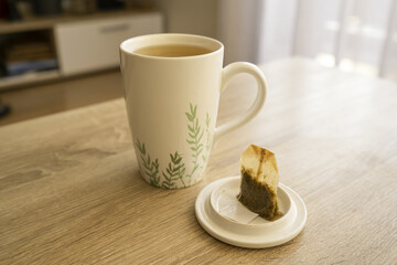 A mug of tea on a wooden table, sun, warm, cold. High quality photo