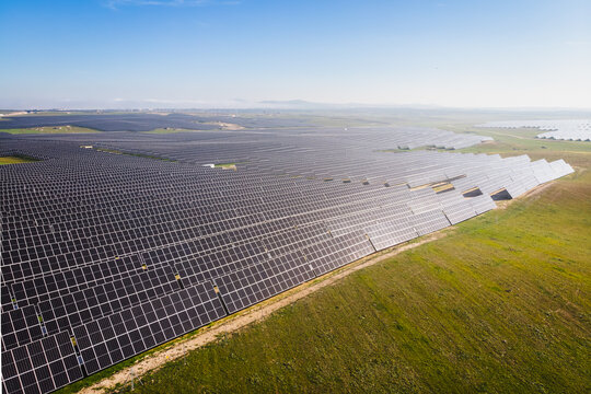 A large field of solar panels is seen from above