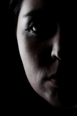 Side lit silhouette portrait of a girl against black background