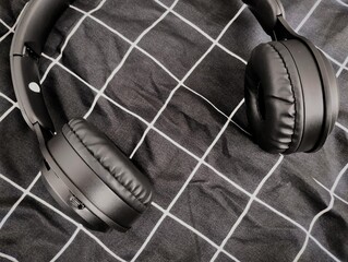 Photography of black earphones with a black striped background. Black earphones digital tool for...