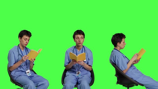 Health specialist is reading a literature book to acquire physician specialization and surgeon expertise, sitting in a chair. Nurse studying healthcare industry lecture against greenscreen. Camera B.
