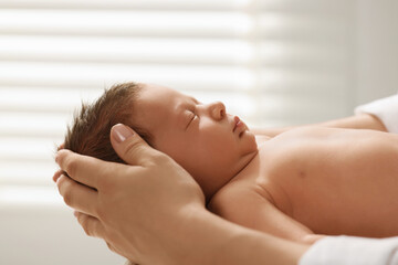 Obraz na płótnie Canvas Mother holding her cute newborn baby indoors, closeup