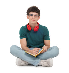 Portrait of student with notebook and headphones sitting on white background