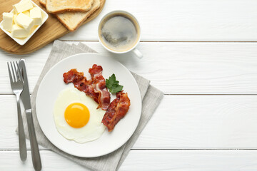 Delicious breakfast with sunny side up egg served on white wooden table, flat lay. Space for text