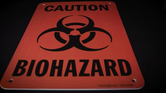 Caution biohazard orange sign on dark background