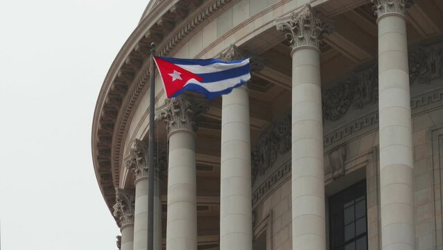 Cuban flag waving in wind at building of Capitol in Havana, Cuba