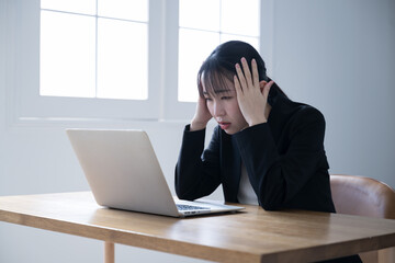 Woman with head in front of computer Images of headaches, work problems, failures, mistakes, investments, etc.