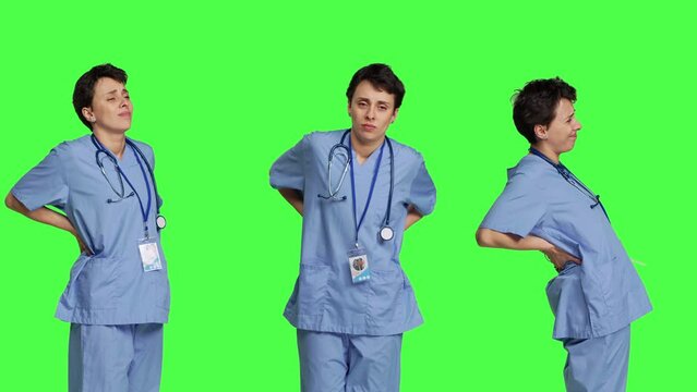 Health specialist suffering from lower back pain after working after hours, feeling in pain and overworked with night shifts. Nurse having spine discomfort from scoliosis and bad posture. Camera B.