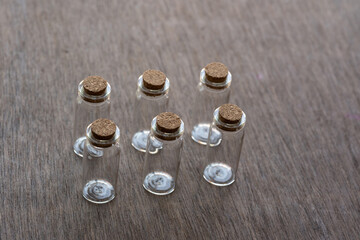 tapas de corcho en frascos de vidrio sobre mesa de madera, vista casi cenital.