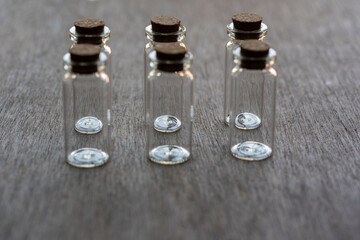seis frascos de vidrio en formación ordenada sobre mesa de madera
