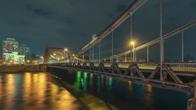 Grunwald Bridge over the river Oder in Wrocław night time lapse.  Grunwald Bridge (Polish: Most Grunwaldzki) is a suspension bridge over the river Oder in Wrocław, Poland, built between 1908 and 1910.