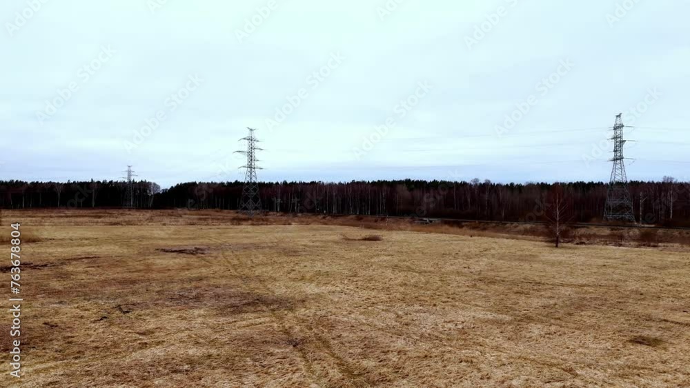 Poster three high voltage electricity lines. a field with tall power lines in the background. the sky is cl