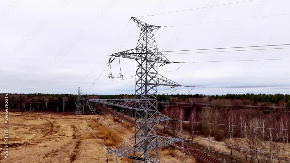 Poster a tall power tower is seen in a field with a cloudy sky in the background. concept of power and ener