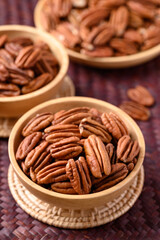 Raw peeled pecan nuts in wooden bowl, Food ingredient