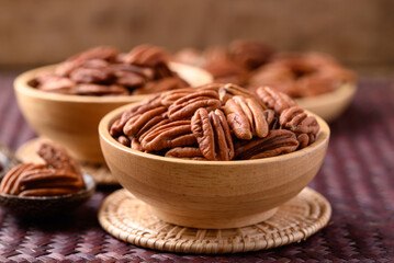 Raw peeled pecan nuts in wooden bowl, Food ingredient