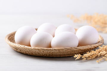 Organic white leghorn egg from free range farm in natural basket - obrazy, fototapety, plakaty