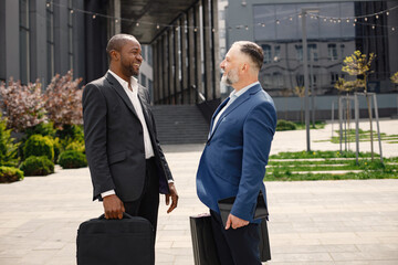 Business people standing and talk to each other in front of modern office