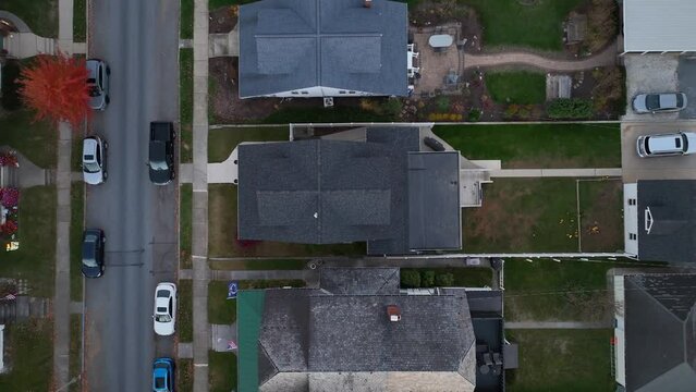 Rooftops of town houses at night in USA. Aerial top down descending shot above quaint family home in neighborhood in American town during autumn evening.