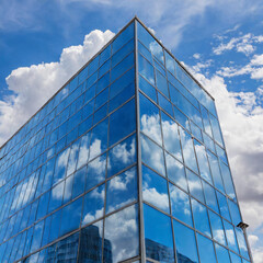 blue glass building with clouds reflected in the window outdoors
