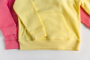 Yellow and red  hoodies mockup on the white background. Crop view. Fashion outfit, casual style. Basic stylish clothing.