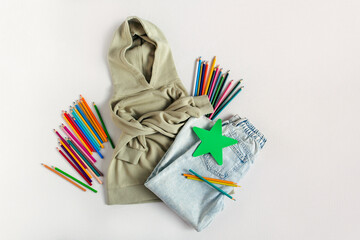 Green  hoodie with jeans and pencils. Sweatshirt with accessories on the white background. Fashion outfit, casual style. - Powered by Adobe