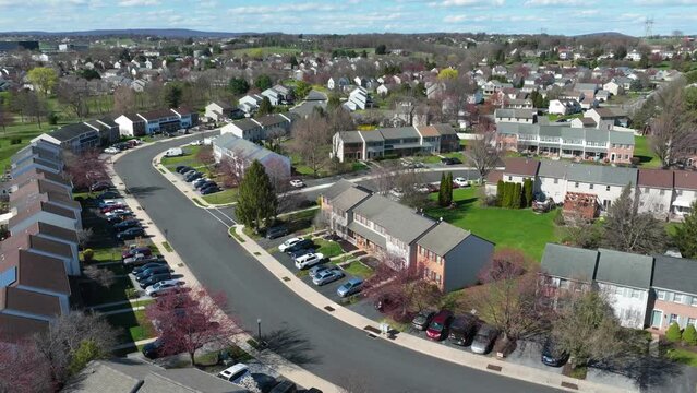 Hyperlapse flight over street with two story family homes in USA, American neighborhood residential community. Aerial above road, golden sunshine light. Drone flyover.
