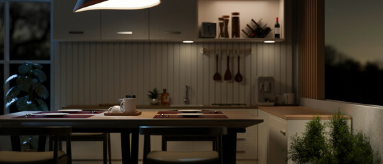 A dining table in a contemporary kitchen with kitchen appliances and decor at night.