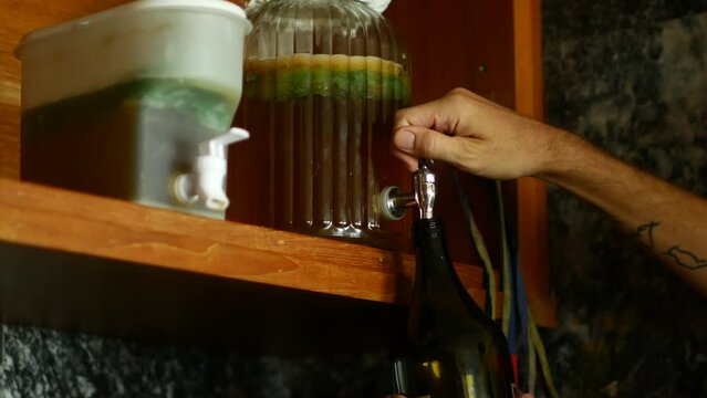 Pouring Kombucha from Large Dispenser Jar