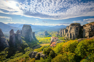 Meteora, Greece. Panoramic landscape of Meteora, Greece at romantic sundown time with real sun and sunset sky. Meteora - incredible sandstone rock formations.   Greece, Meteora - 763716826