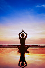 vertical yoga background, woman practices yoga meditation and mindfulness at sunset beach, copyspace