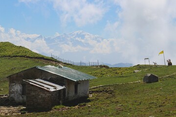 a hut in the panaar meadow with himalayan range in background of rudranath trek uttarakhand