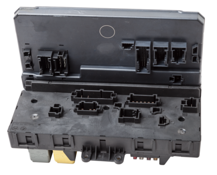 Metallic car engine control unit with plastic elements soaring on a white isolated background is connecting center of various subsystems, units and assemblies. Spare part.