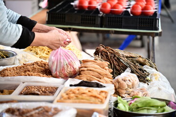 A close-up shot of a pickled vegetable stall in the market, with various pickled food items...