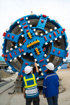 Engineer to wear workwear clothing safety. Technician control underground tunnel construction at working shaft. Transport pipeline by Tunnel Boring Machine(TBM) method for electric train subway.