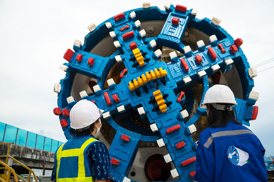 Engineer to wear workwear clothing safety. Technician control underground tunnel construction at working shaft. Transport pipeline by Tunnel Boring Machine(TBM) method for electric train subway.