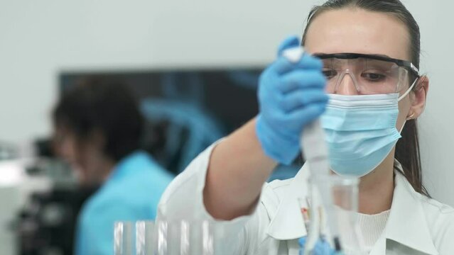 Female scientist using a micropipette for analysis in a modern laboratory. Advanced scientific laboratory of medicine and biotechnology development. Close-up