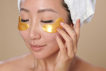 Young woman applying undereye patches to get rid of puffiness