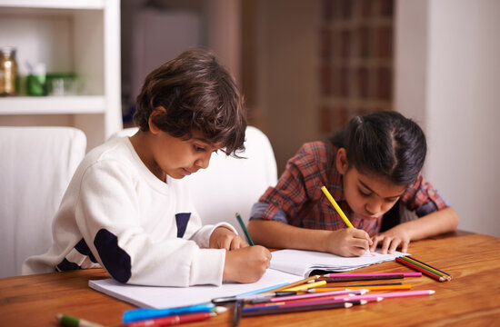 Education, remote learning and siblings in a kitchen with book, writing or homework assignment in their home. Notebook, homeschool and children studying in a house with help, support or art lesson