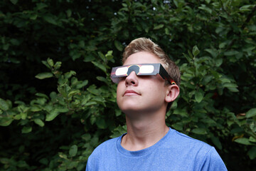 Boy watching the eclipse of the sun - obrazy, fototapety, plakaty