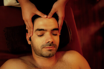 Caucasian man enjoying relaxing anti-stress head massage and pampering facial beauty skin...