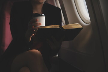 Blonde female tourist checking incoming notification on smartphone sitting on seat of airplane with...