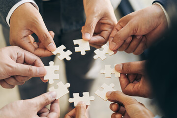 The concept of teamwork and partnership. Businessman's hands putting together puzzle pieces in the office and join together in a jigsaw puzzle team. Charity. Volunteers. Business unity as a team.