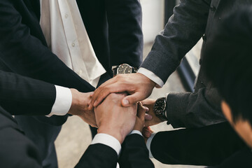 Close up of group of business people joining their hands together in unity.