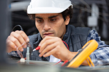 electrician testing spotlight with multimeter