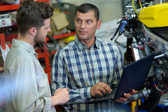 mechanic using a laptop computer to check an engine