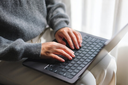 Closeup image of a woman typing on laptop computer keyboard