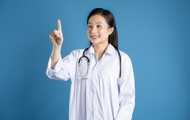 Image of Asian female doctor posing on a blue background