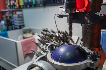 Drilling holes with a drill bit into bowling ball. Preparing bowling ball for a customer, custom...